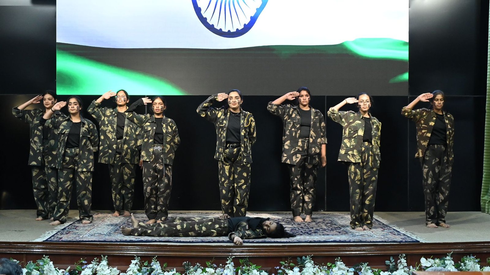 Cadets salute on stage in front of the tricolour at Sena Samvad